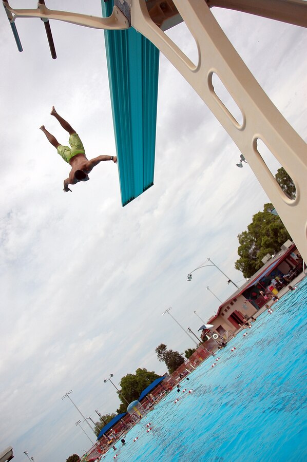 Lance Cpl. Dane Howard backflips off the high dive at the John F. Kennedy Pool in Yuma, Ariz., during the Headquarters and Headquarters Squadron family day dive contest July 24, 2009. Approximately 420 squadron service members and family members attended the social gathering, which was sponsored by Marine Corps Community Services. Chief Warrant Officer 2 David Mangum and Lance Cpl. James Brands both received a golf club for winning the biggest splash and best dive contests during the event.