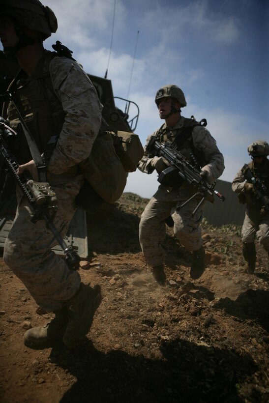 Marines with Company G, Battalion Landing Team 2/4 rush across a simulated village during a mechanized raid on Catalina Island July 23. Marines began the operation from USS Rushmore on assault amphibious vehicles, which were then used to proceed to the objective. The raid was the second of three Co. G will perform from ship before deploying with the 11th Marine Expeditionary Unit.