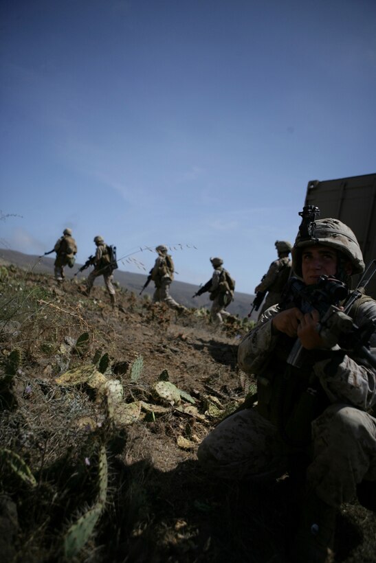 Lance Cpl. Stephen P. Bond, 19, from North Olmsted, Ohio, provides security while members of his squad move from one building to another during a mechanized raid on Catalina Island July 23. For many Marines the Island was unfamiliar territory, creating a more realistic raid experience. Marines arrived to the raid site on amphibious assault vehicles, which they rode from USS Rushmore. This raid was the second of three Co. G will perform from ship to shore before deploying with the 11th Marine Expeditionary Unit later this year.