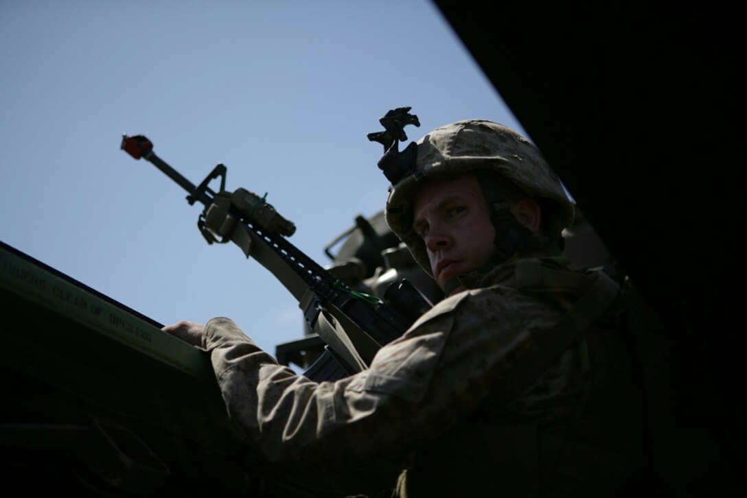 Lance Cpl. Caleb D. Eggert, 22, from Tupelo, Miss., positions himself to provide security for the amphibious assault vehicle he is riding in after completing a mechanized raid on Catalina Island July 23. The raid was the second of three Company G will conduct from USS Rushmore before deploying with the 11th Marine Expeditionary Unit later this year.