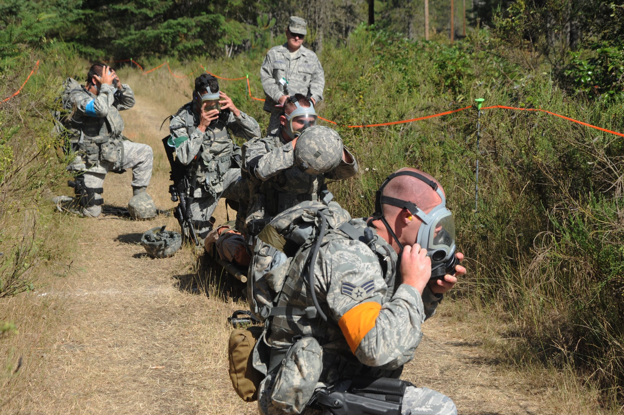 Members of Team Little Rock put on their gas masks during the Combat Weapons Course at Fort Lewis, Wash., as part of Air Mobility RODEO 2009, July 20. RODEO is an international combat skills and flying operations competition designed to develop and improve techniques and procedures with our international partners to enhance mobility operations. Teams participating in the Combat Weapons Course were evaluated on marksmanship, first aid, and the ability to operate in a contaminated environment. (U.S. Air Force photo by Staff Sgt. Christine Jones) (Released)