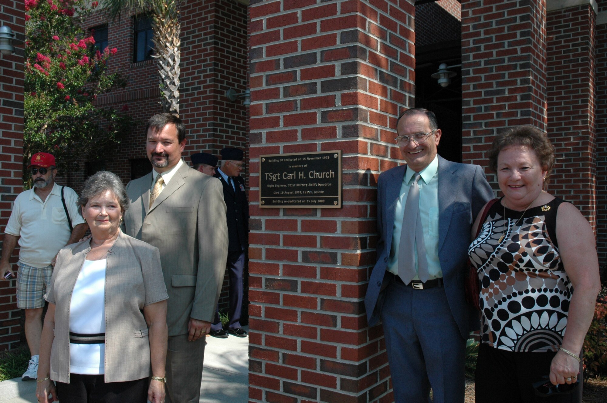 Family members pose by a new plaque honoring Carl H. Church at a building rededication cermemony at the 315th Airlift Wing headquarters building. (U.S. Air Force/Staff Sgt. Scott Mathews)