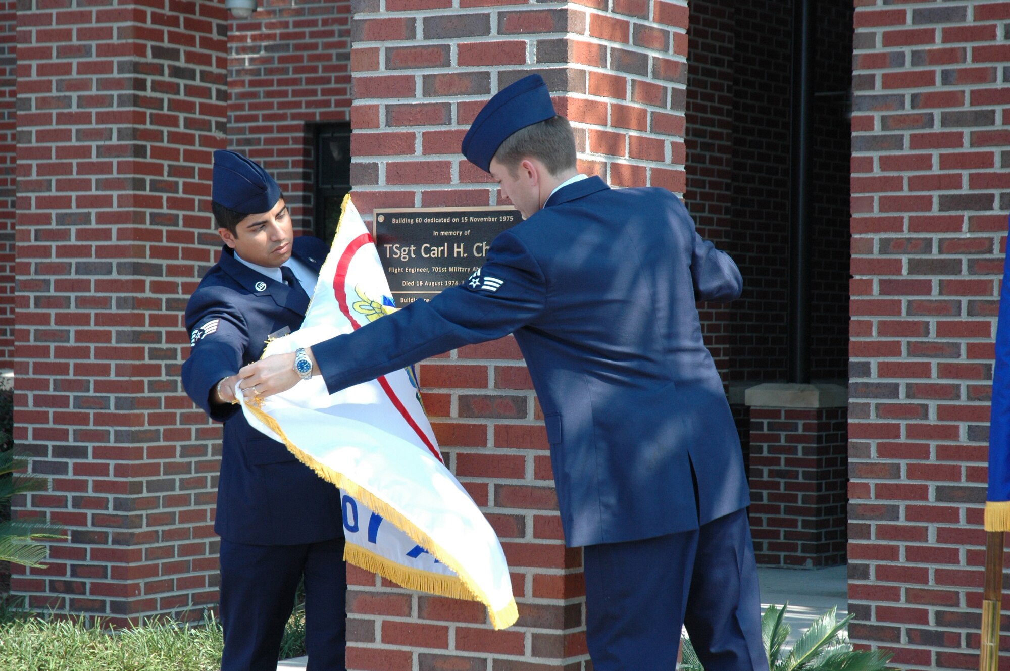 Airmen unveil the new plaque in a building rededication ceremony honoring Tech Sgt. Carl H. Church at the 315th Wing headquarters building. (U.S. Air Force photo/Staff Sgt. Scott Mathews)