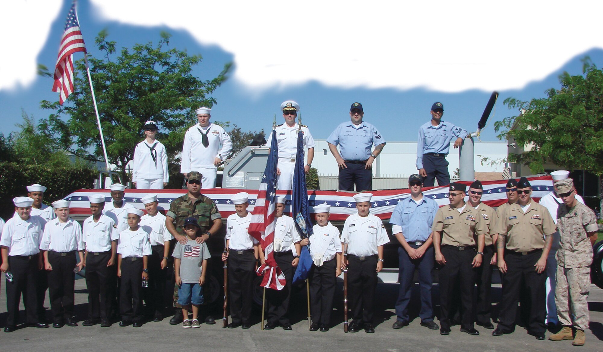 Sea Cadets and NOSC Moreno Valley reservists stand in front of their parade vehicle (a Navy RHIB mounted on a trailer) at the Moreno Valley July 4th Parade. 