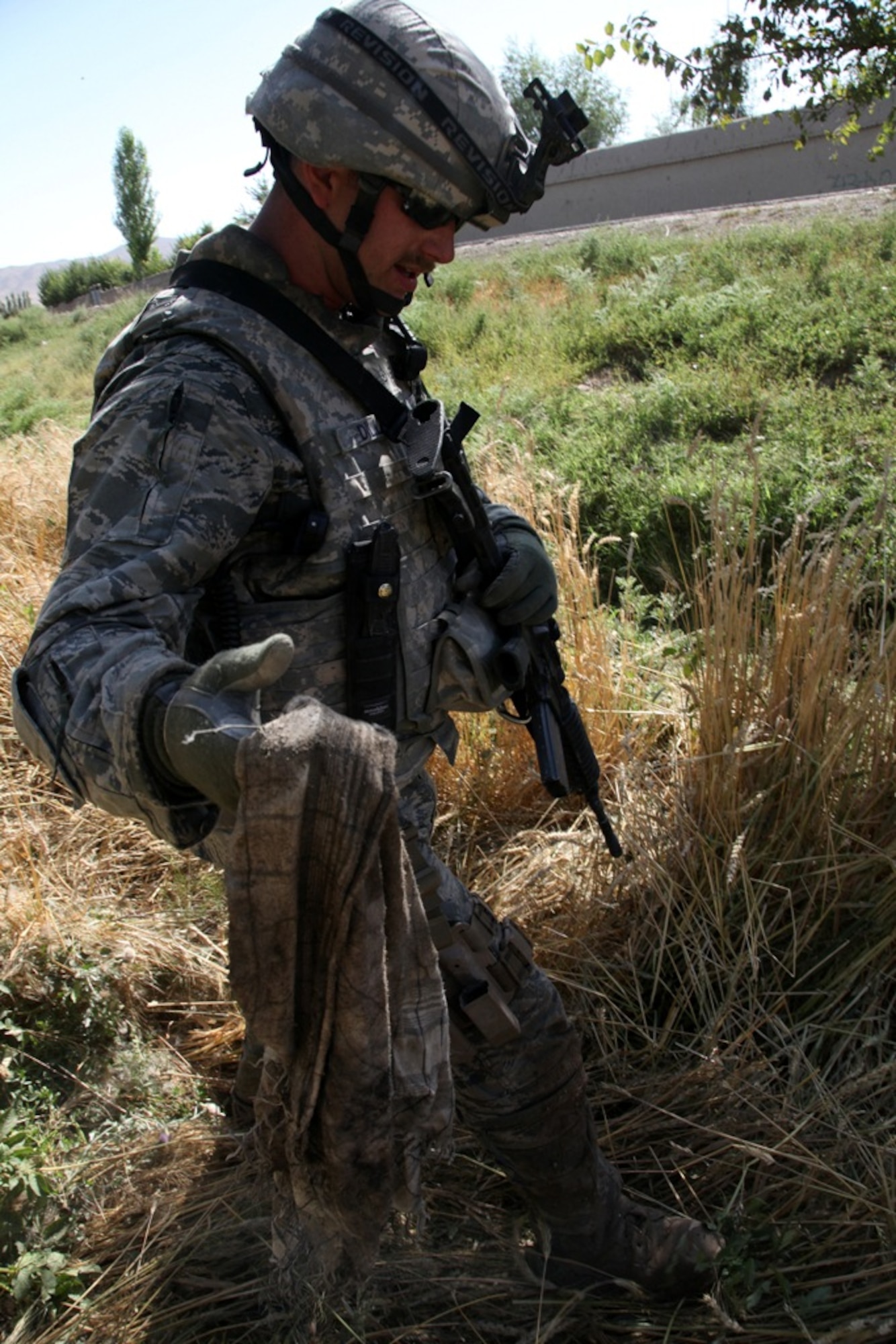LOGAR PROVINCE, Afghanistan - Staff Sgt. Carl Dill collects the bag that covered an Improvised Explosive Device in Logar province, Afghanistan, July 15. Dill is currently assigned to the 741st Explosive Ordnance Device Battalion, Task Force Spartan, 3rd Brigade Combat Team, 10th Mountain Division. (U.S. Army photo/Pfc. Richard W. Jones Jr.) 