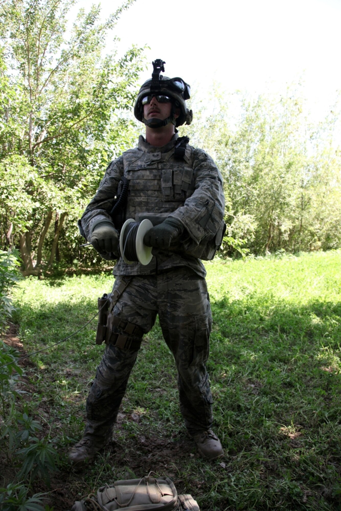 LOGAR PROVINCE, Afghanistan -  Air Force Staff Sgt. Carl Dill uncoils the charging wire for a controlled detonation in Logar Province, Afghanistan, July 15. Dill is currently assigned to the 741st Explosive Ordnance Device Battalion, Task Force Spartan, 3rd Brigade Combat Team, 10th Mountain Division. (U.S. Army photo/Pfc. Richard W. Jones Jr.)