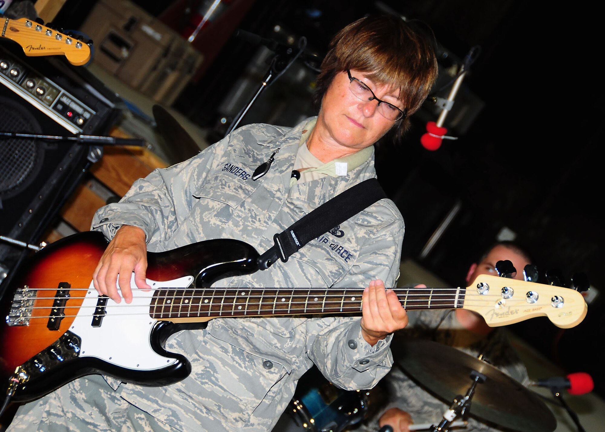 CAMP BUCCA, Iraq-- Master Sgt. Beth Sanders, Air Force Central Command Sonora band, plays bass guitar during a performance for members of Camp Bucca, Iraq on July 22.  Sonora offers a diverse performance repertoire featuring acoustic, electric and bass guitars, keyboards, drums, saxophone and trumpet.  Vocalists round-out the mix and an expert engineer brings it all together.  Sergeant Sanders is deployed from the 129th Rescue Wing, Moffet Federal Air Field, Calif., hails from Stockton, Calif.  (U.S. Air Force photo/Tech Sgt. Tony Tolley)