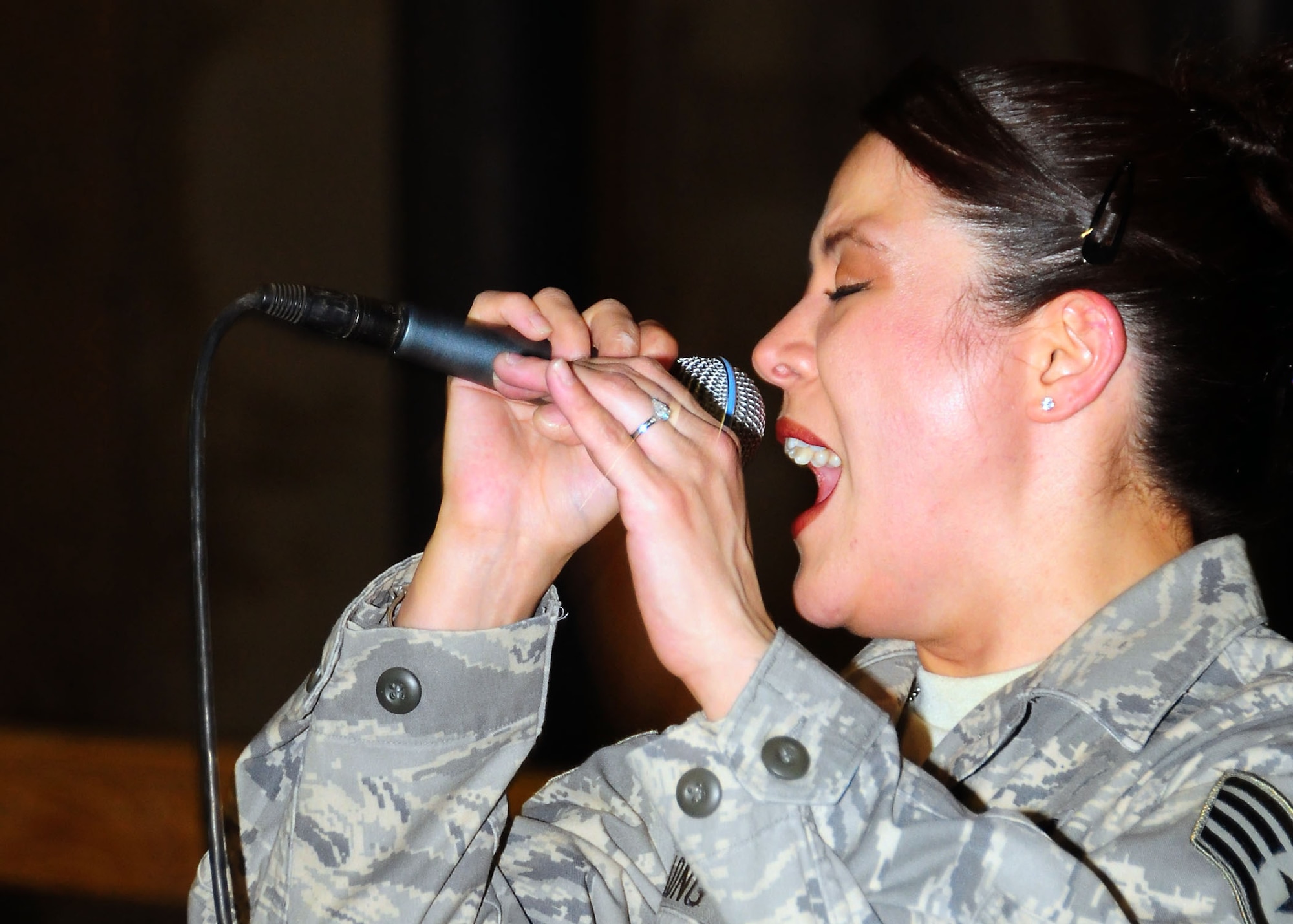 CAMP BUCCA, Iraq-- Staff Sgt. Angie Long, Air Force Central Command Sonora band, sings during a performance for members of Camp Bucca, Iraq on July 22.  Sonora offers a diverse performance repertoire featuring acoustic, electric and bass guitars, keyboards, drums, saxophone and trumpet.  Vocalists round-out the mix and an expert engineer brings it all together.  Sergeant Long is deployed from the 131st Fighter Wing, Air National Guard, Mo., and hails from Nashville, Tenn.  (U.S. Air Force photo/Tech Sgt. Tony Tolley)