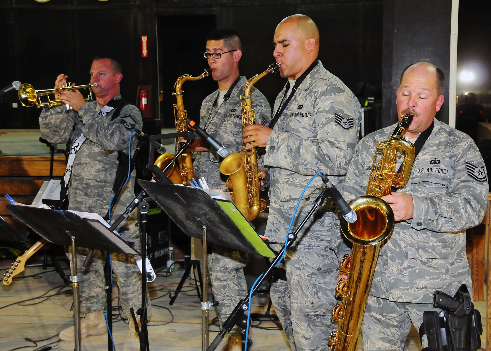 CAMP BUCCA, Iraq-- (From left to right), Master Sgt. Michael Baker on the trumpet, Staff Sgt. Jorge Cruz, saxophone, Staff Sgt. Antonio Galindo, saxophone and Tech. Sgt. Brian Coggins, saxophone, Air Force Central Command band Sonora perform for members of Camp Bucca, Iraq, during a performance on July 22.  Sonora offers a diverse performance repertoire featuring acoustic, electric and bass guitars, keyboards, drums, saxophone and trumpet.  Vocalists round-out the mix and an expert engineer brings it all together.  Sergeant Baker is deployed from the 141st Air Refueling Wing, Fairchild Air Force Base, Wash., hails from Spokane, Wash., Sgt Cruz is deployed from the 129th Rescue Wing, Moffet Federal Air Field, Calif., hails from Richmond, Calif., Sgt. Galindo is deployed from the 129th Rescue Wing, Moffet Federal Air Field, Calif., hails from Los Banos, Calif., and Sgt. Coggins is deployed from the 129th Rescue Wing, Moffet Federal Air Field, Calif., hails from San Jose, Calif.  (U.S. Air Force photo/Tech Sgt. Tony Tolley)