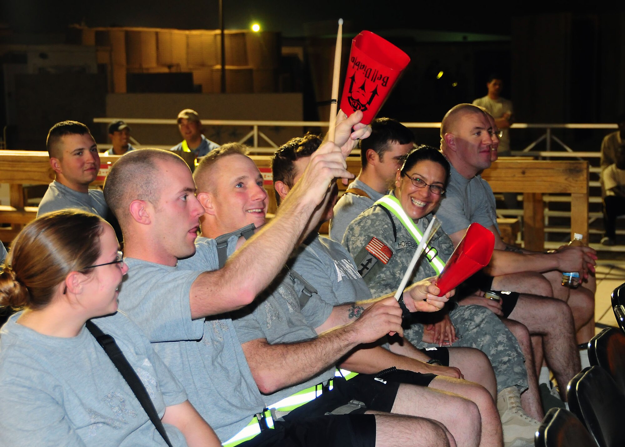 CAMP BUCCA, Iraq-- Members of Camp Bucca, Iraq, join in on the musical performance by the Air Force Central Command Sonora band, by banging cow bells on July 22.  Sonora offers a diverse performance repertoire featuring acoustic, electric and bass guitars, keyboards, drums, saxophone and trumpet.  Vocalists round-out the mix and an expert engineer brings it all together.  (U.S. Air Force photo/Tech Sgt. Tony Tolley)
