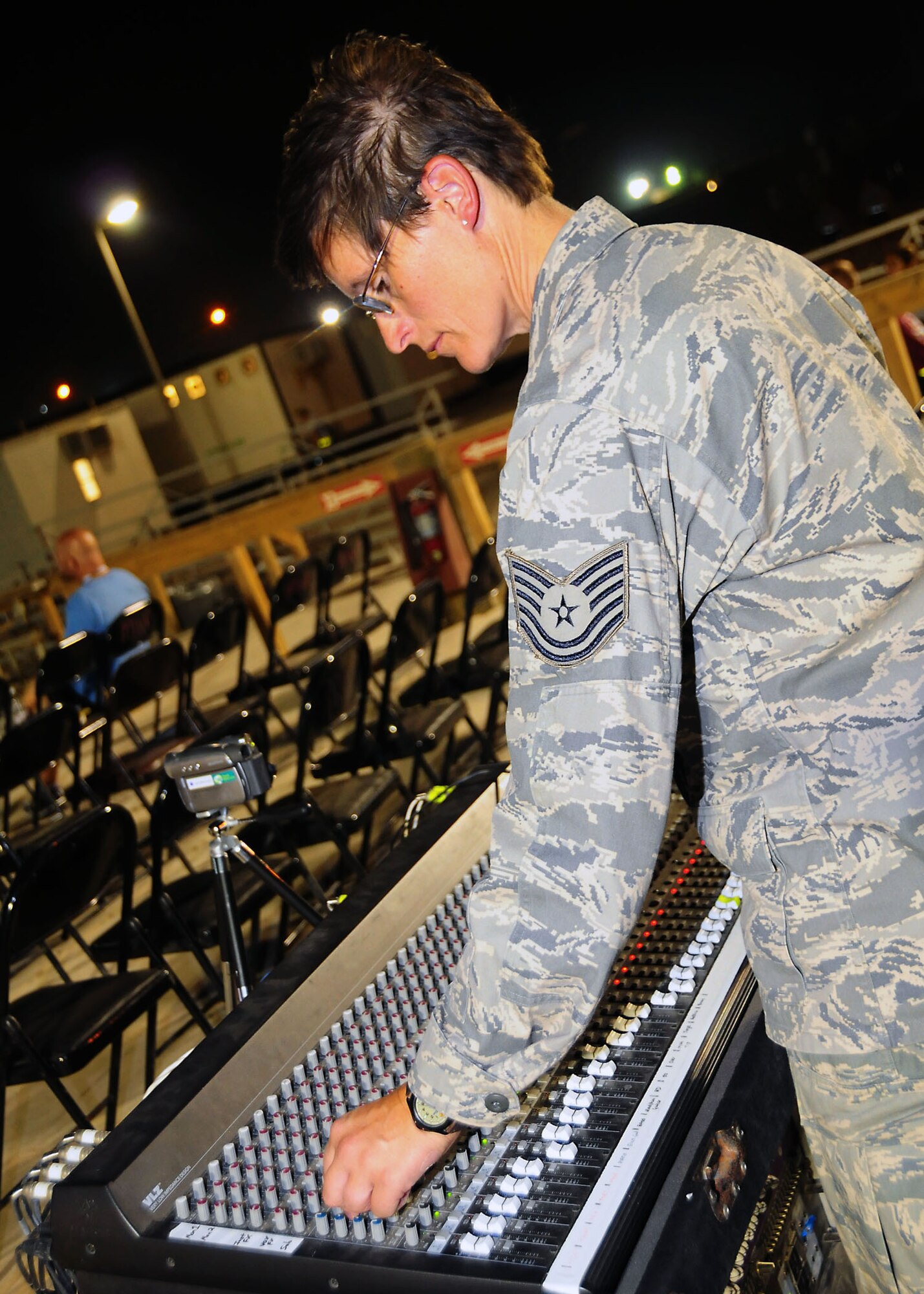 CAMP BUCCA, Iraq-- Tech. Sgt. Lindsey Bartlett, Air Force Central Command Sonora band, adjusts the sound during a performance for members of Camp Bucca, Iraq on July 22.  Sonora offers a diverse performance repertoire featuring acoustic, electric and bass guitars, keyboards, drums, saxophone and trumpet.  Vocalists round-out the mix and an expert engineer brings it all together.  Sergeant Bartlett is deployed from the 129th Rescue Wing, Moffet Federal Air Field, Calif.  (U.S. Air Force photo/Tech Sgt. Tony Tolley)