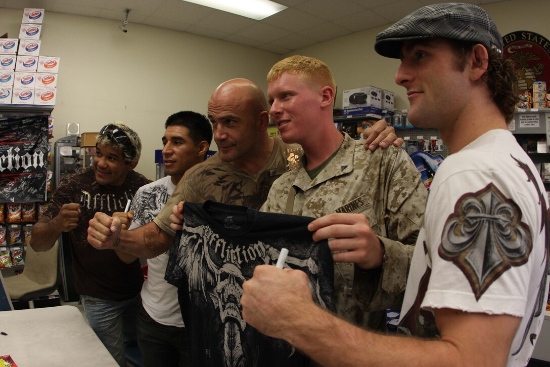 Several Affliction fighters pose with Lance Cpl. Stephen Ducey, a motor vehicle operator with Transportation and Support Company, Combat Logistics Battalion 46, after Ducey won an Affliction T-shirt in a raffle at the Camp Wilson Exchange July 26.