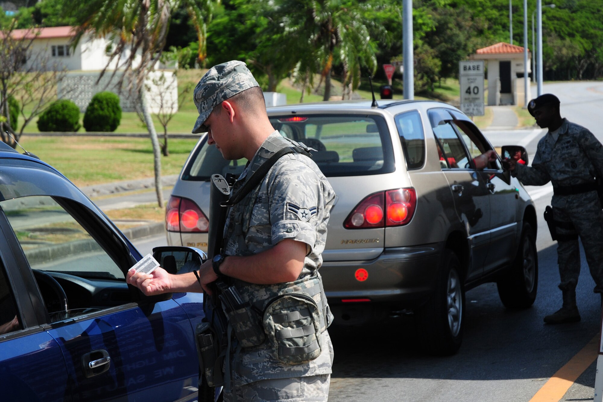 Airman 1st Class Billy Kessell, 18th Component Maintenance Squadron, along with Airman Kevin Bell, 18th Security Forces Squadron, check identification cards at Gate 3, Kadena Air Base, July 23. Airmen were called upon to volunteer for augmentee duty to help alleviate manning shortfalls in the 18th SFS. (U.S. Air Force photo/Airman 1st Class Amanda Grabiec)
