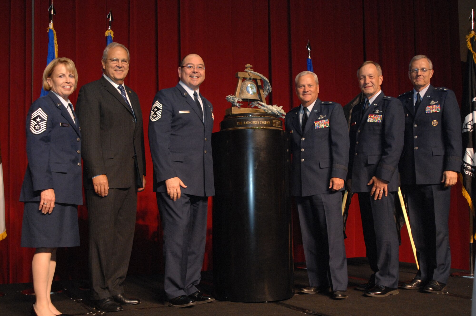 From left to right, Chief Master Sgt. Patricia Thornton, Fourth Air Force Command Chief; Mr. Roger Rupp, Greater Riverside Chambers of Commerce Military Affairs Committee Chairman; Brig. Gen. James Melin, 452nd Air Mobility Wing Commander; Chief Master Sgt. Agustin Huerta, 452nd AMW Command Chief;  Brig. Gen. Eric W. Crabtree, Headquarters Fourth Air Force  Commander; and Maj. Gen. John M. Howlett, Deputy Director, U.S. Strategic Command, pose with the Raincross Trophy after it was awarded to the 452nd AMW during the 11th Annual Raincross Trophy Dinner held July 23, 2009, at the Riverside Convention Center, Riverside, Calif.. The dinner is hosted by the Greater Riverside Chambers of Commerce Military Affairs Committee to honor and recognize the 11 wings and two groups in 4th Air Force.  (U.S. Air Force photo/ Senior Master Sergeant Kim Allain)  (released)