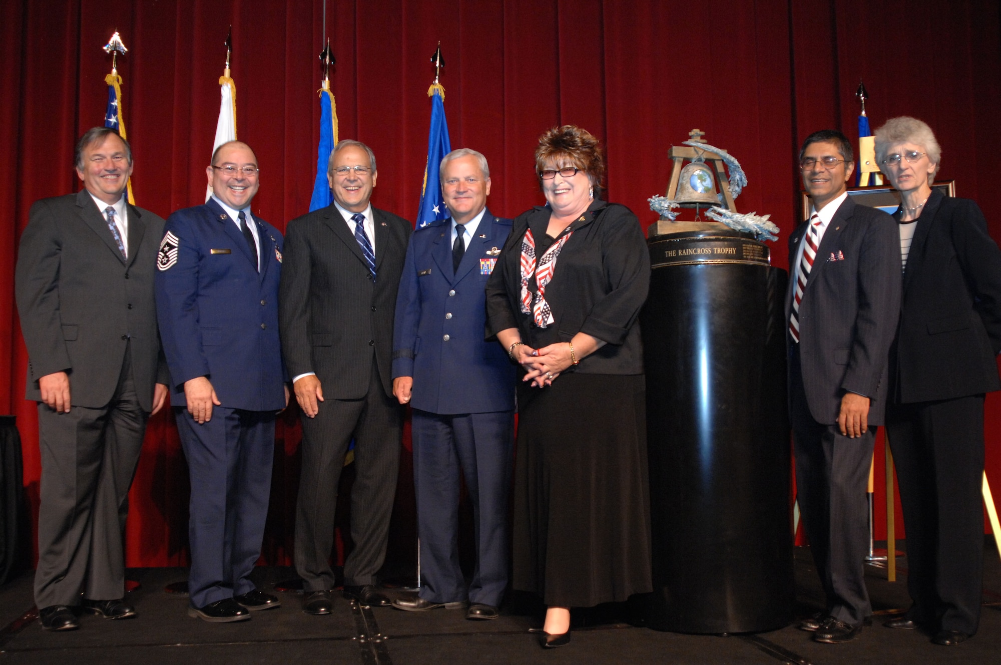 From left to right, Mr. Mike Vanderpool; Chief Master Sgt. Agustin Huerta, 452nd Air Mobility Wing, March Air Reserve Base, Calif., Command Chief; Mr. Roger Rupp; Brig. Gen. James Melin, Commander, 452nd AMW; Ms. Laura Froehlich; Mr. Jamil Dada; and Co. (ret) Nancy Driscoll, pose with the Raincross Trophy after it was awarded to the 452nd AMW at the 11th Annual Raincross Trophy Dinner held July 23, 2009, at the Riverside Convention Center, Riverside, Calif. The dinner is hosted by the Greater Riverside Chambers of Commerce Military Affairs Committee to honor and recognize the 11 wings and two groups in 4th Air Force.  (U.S. Air Force photo/Senior Master Sgt. Kim Allain)  (released)