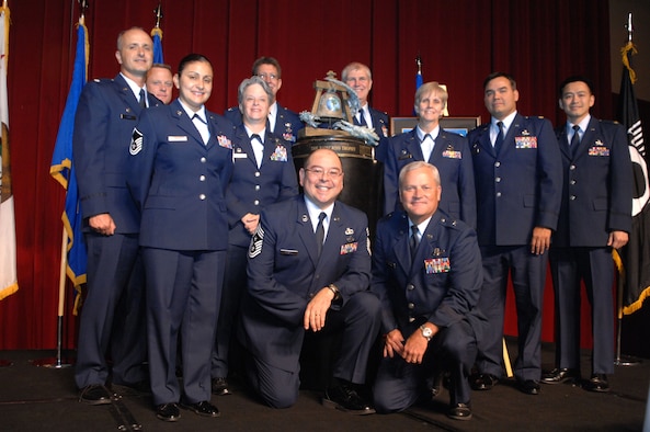 Members of the 452nd Air Mobility Wing, March Air Reserve Base, Calif., along with Command Chief Master Sgt. Agustin Huerta, and Commander, Brig. Gen.l James Melin, front and center, pose with the Raincross Trophy after it was awarded to the 452nd AMW at the 11th Annual Raincross Trophy Dinner held July 23, 2009, at the Riverside Convention Center, Riverside, Calif. The dinner is hosted by the Greater Riverside Chambers of Commerce Military Affairs Committee to honor and recognize the 11 wings and two groups in 4th Air Force.  (U. S. Air Force photo/Senior Master Sgt. Kim Allain)  (released)