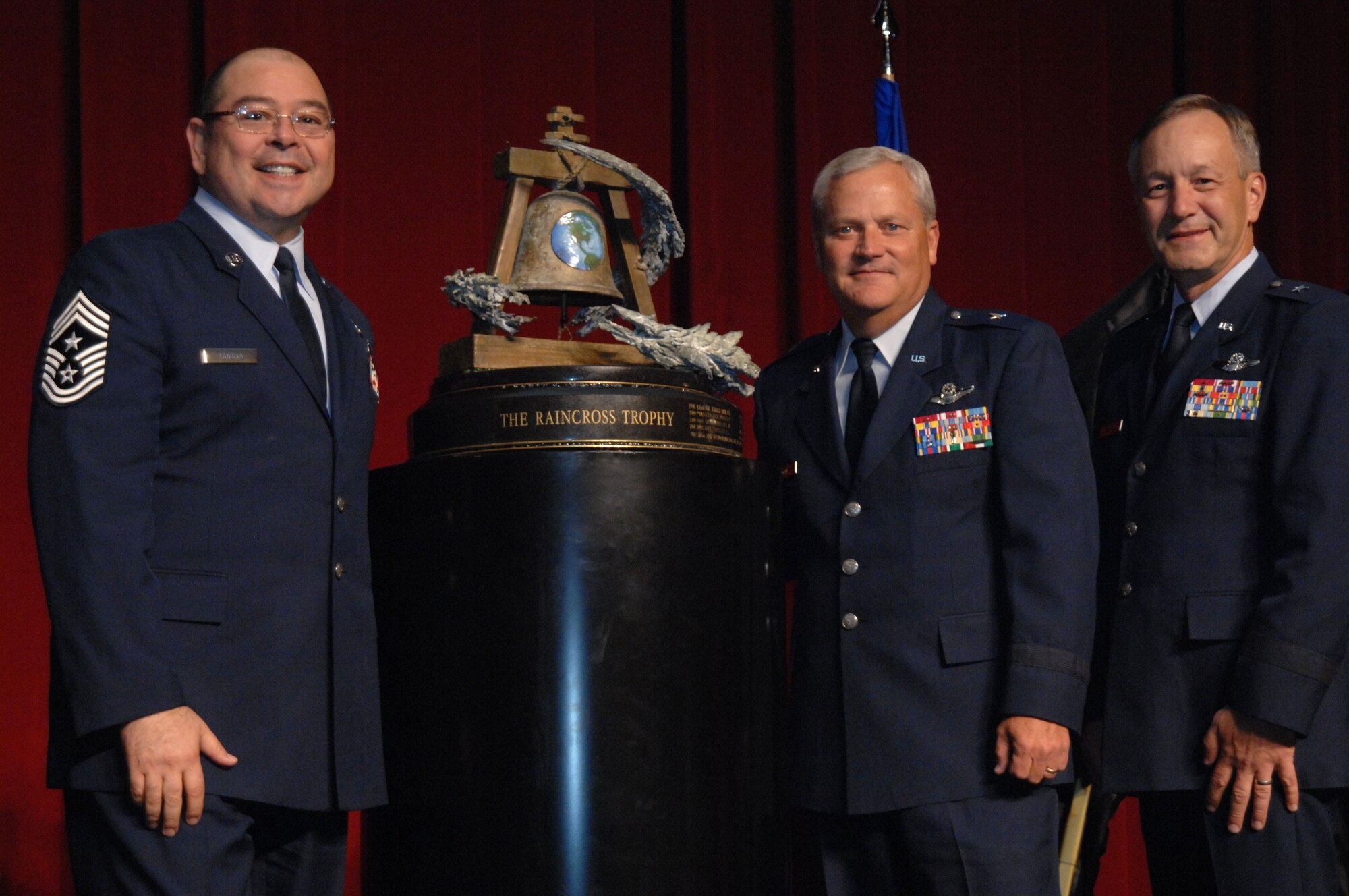 Chief Master Sgt. Agustin Huerta, 452nd Air Mobility Wing Command Chief, March Air Reserve Base, Calif.  left, Brig. Gen. James Melin, center, 452nd AMW Commander, and Brig. Gen. Eric W. Crabtree, right, Commander, Fourth Air Force, pose with the Raincross Trophy after it was awarded to the 452nd AMW during the 11th Annual Raincross Trophy Dinner held July 23, 2009, at the Riverside Convention Center, Riverside, Calif. The dinner is hosted by the Greater Riverside Chambers of Commerce Military Affairs Committee to honor and recognize the 11 wings and two groups in 4th Air Force.  (U. S. Air Force photo/Senior Master Sgt. Kim Allain)  (released)