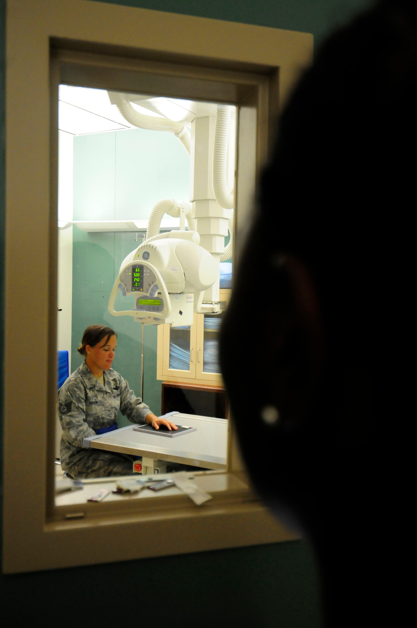 ANDERSEN AIR FORCE BASE, Guam - Staff Sgt. Aisha Toston, 36th Medical Group noncommissioned  officer in charge of radiology, takes a hand series of Tech. Sgt. Andrea Inmon's, 36th Mobility Response Group ramp coordinator, injured hand here July 17. The radiology clinic services around 15 patients per day conducting routine radiographs. (U.S. Air Force photo by Airman 1st Class Courtney Witt)