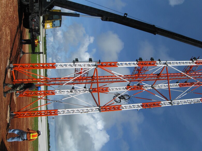 ANDERSEN AIR FORCE BASE, Guam - Members of the 36th Communications Squadron and civilian contractors use a crane to erect an instrument landing system on the flightline here. The system is one of four new Selex 2100 Series instrument landing systems to be added to the flightline. These systems enable aircraft to safely land on the runway in austere flying conditions. (Courtesy photo)