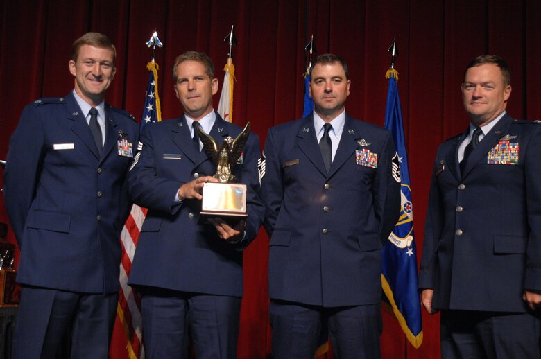 From left to right, Lt. Col. Tom Jensen, Chief Master Sgt. Jim Masura, Master Sgt. Scott Dellinger and Col. Dave Pavey, 446th Operations Group Commander, pose with The Aircrew Excellence Award which was awarded to the crew from the 446th Airlift Wing, McChord, AFB, Wash., at the 11th Annual Raincross Trophy Dinner held July 23, 2009, at the Riverside Convention Center, Riverside, Calif. The dinner is hosted by the Greater Riverside Chambers of Commerce Military Affairs Committee to honor and recognize the 11 wings and two gropus in 4th Air Force.  (U.S. Air Force photo/Senior Master Sgt. Kim Allain)  (released)