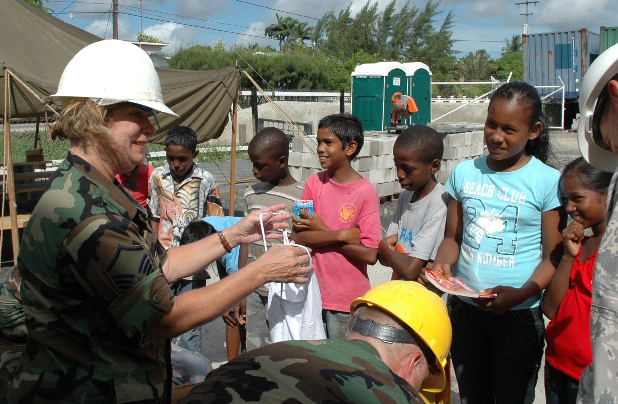GEORGETOWN, Guyana — Air Force Reserve Master Sgt. Christina Adamovich offers local Guyanese girls a top to wear.  Deploying members of the 910th Civil Engineer Squadron donated clothes and school supplies to the students as part of their outreach to build a new much needed school.  The single level school building is scheduled for dedication in September.  U. S. Air Force Photo/Maj. Brent J. Davis  