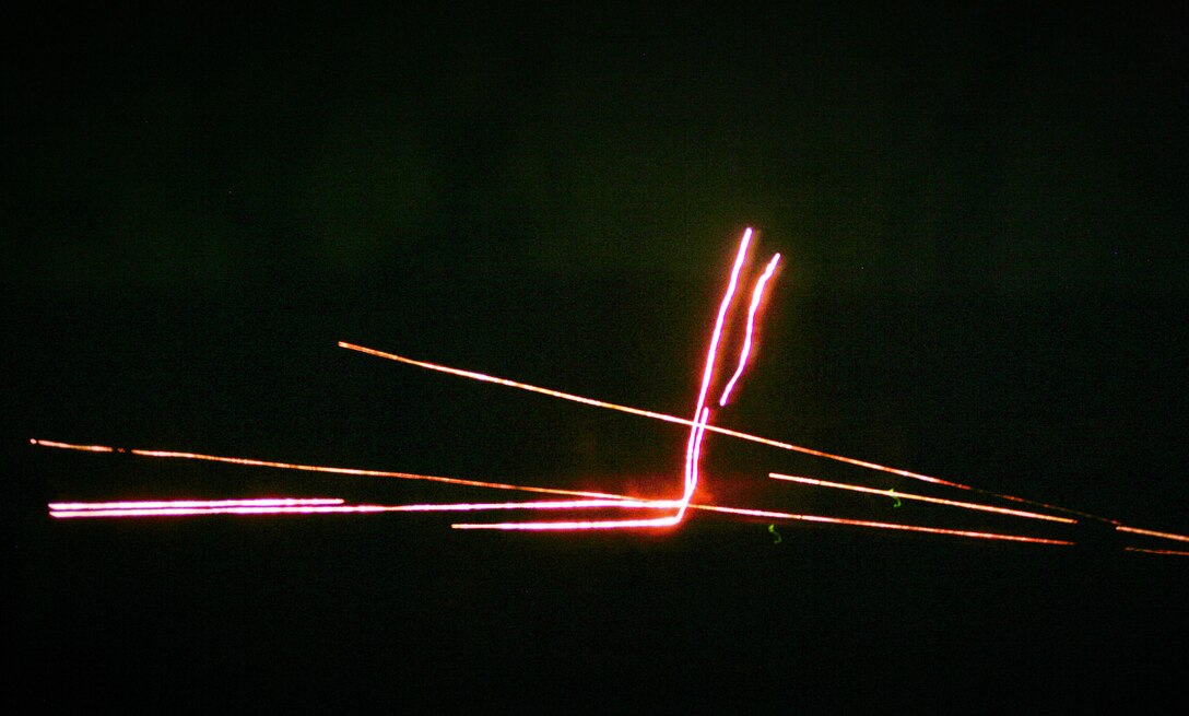 Tracer rounds from machine gun bursts cross paths and ricochet as they hit their targets during a live-fire night raid conducted by Company G here July 26. The company is part of Battalion Landing Team 2/4, the ground combat element of the 11th Marine Expeditionary Unit. The MEU, comprised of 2,200 Marines and sailors, is currently training at sea, in the air and on land before it deploys later this year.