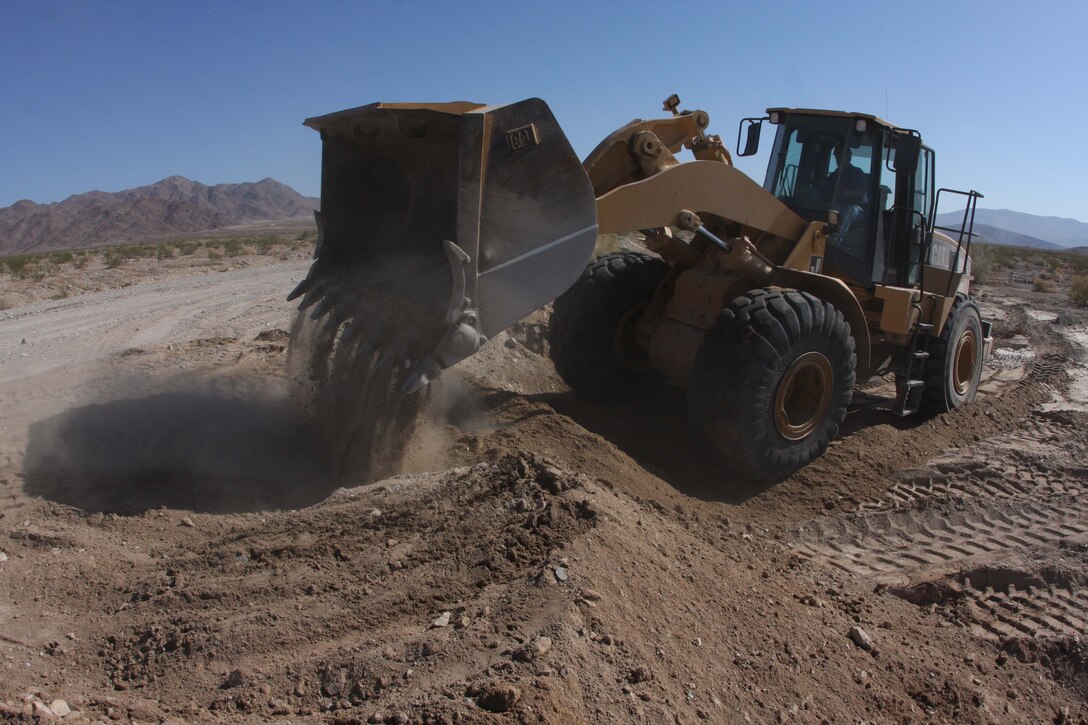Mark Carrington, the Range/Training Area Maintenance Section officer in charge, rebuilds a road barrier heading to Range 410A that was washed out by a recent rain storm.