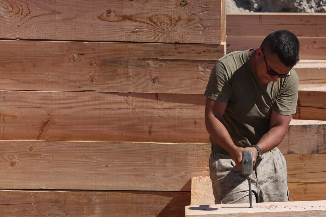 Lance Cpl. Anthony Young, an airframes mechanic with the Range/Training Area Maintenance Section, helps rebuild a bunker July 28 which burned down during training at Combat Center Range 410A. RTAMS relies on Marines of all skills and military occupational specialties to keep ranges up and running for training units.