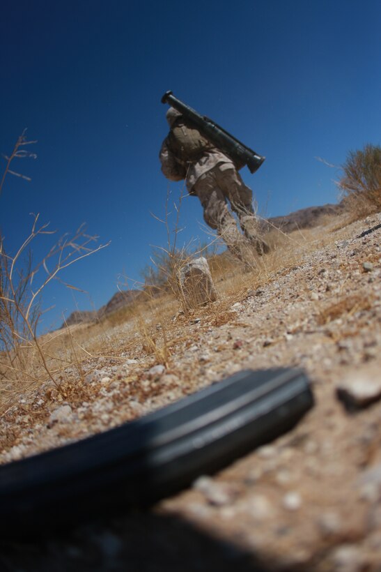 Pfc. Jacob Fry, a rifleman with Company K, 3rd Battalion, 7th Marine Regiment, and a native of Malcom, Neb., dashes off into the distance while leaving an empty magazine behind July 28, at Combat Center Range 1A.
