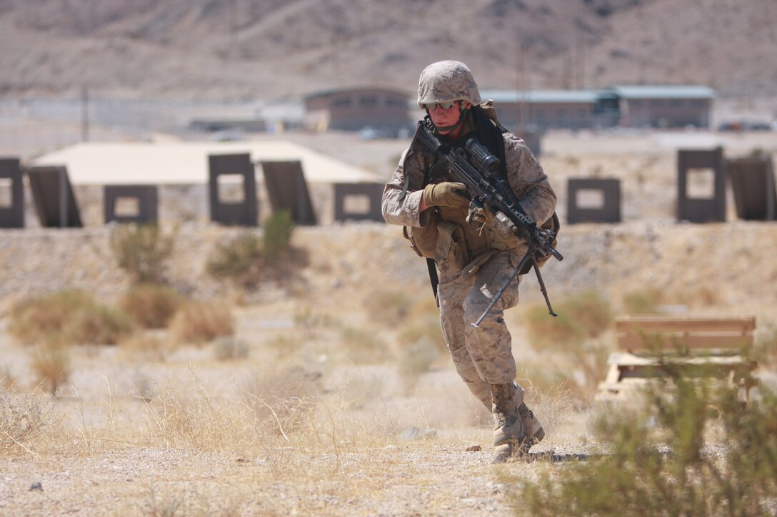 Pfc. Christopher Dion Scott, a rifleman with Company K, 3rd Battalion, 7th Marine Regiment, from Pine City, Minn., rushes while another Marine lays down covering - fire for him July 28, at Combat Center Range 1A during the Company's training.