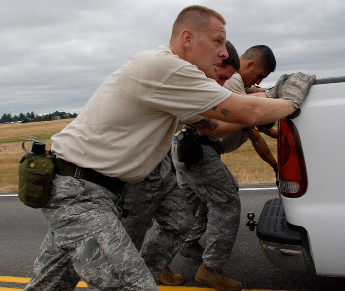 MCCHORD AIR FORCE BASE, Wash. – The 515th Air Mobility Operations Wing Air Mobility Rodeo 2009 Pacific aerial porters Staff Sgt. Travis Wilt, 733rd Air Mobility Squadron, Kadena Air Base, Japan; Staff Sgt. Clifton Robertson, 735th Air Mobility Squadron, Hickam Air Force Base, Hawaii; Senior Airman Tito Valdez, 731st Air Mobility Squadron, Osan Air Base, Korea, Staff Sgt. Dustin Barboza, 734th Air Mobility Squadron, Andersen Air Base, Guam; and Senior Airman Andrew Cramer, 732th Air Mobility Squadron, Elmendorf Air Force Base, Alaska, push a pickup truck during the Aerial Porters Combat Challenge here July 23. During the challenge, aerial porters had to sprint along a four-mile course, stopping to overcome physical and mental obstacles. They finished the entire course in 57 minutes and 26 seconds. The 515th AMOW team is an eight-person group of Airmen who were hand-picked from more than 500 other aerial porters in the Pacific to compete in the Rodeo 2009 competition July 19 to 25 here. Prior to the Rodeo, they trained together at Hickam Air Force Base, Hawaii, for seven weeks. (U.S. Air Force photo/Staff Sgt. Carolyn Viss)