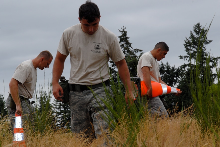 MCCHORD AIR FORCE BASE, Wash. – The 515th Air Mobility Operations Wing Air Mobility Rodeo 2009 Pacific aerial porters Staff Sgt. Travis Wilt, 733rd Air Mobility Squadron, Kadena Air Base, Japan; Staff Sgt. Dustin Barboza, 734th Air Mobility Squadron, Andersen Air Base, Guam; and Senior Airman Tito Valdez, 731st Air Mobility Squadron, Osan Air Base, Korea, attempt to locate and mark unexploded ordnance during the Aerial Porters Combat Challenge here July 23. During the challenge, aerial porters had to sprint along a four-mile course, stopping to overcome physical and mental obstacles. They finished the entire course in 57 minutes and 26 seconds. The 515th AMOW team is an eight-person group of Airmen who were hand-picked from more than 500 other aerial porters in the Pacific to compete in the Rodeo 2009 competition July 19 to 25 here. Prior to the Rodeo, they trained together at Hickam Air Force Base, Hawaii, for seven weeks. (U.S. Air Force photo/Staff Sgt. Carolyn Viss)