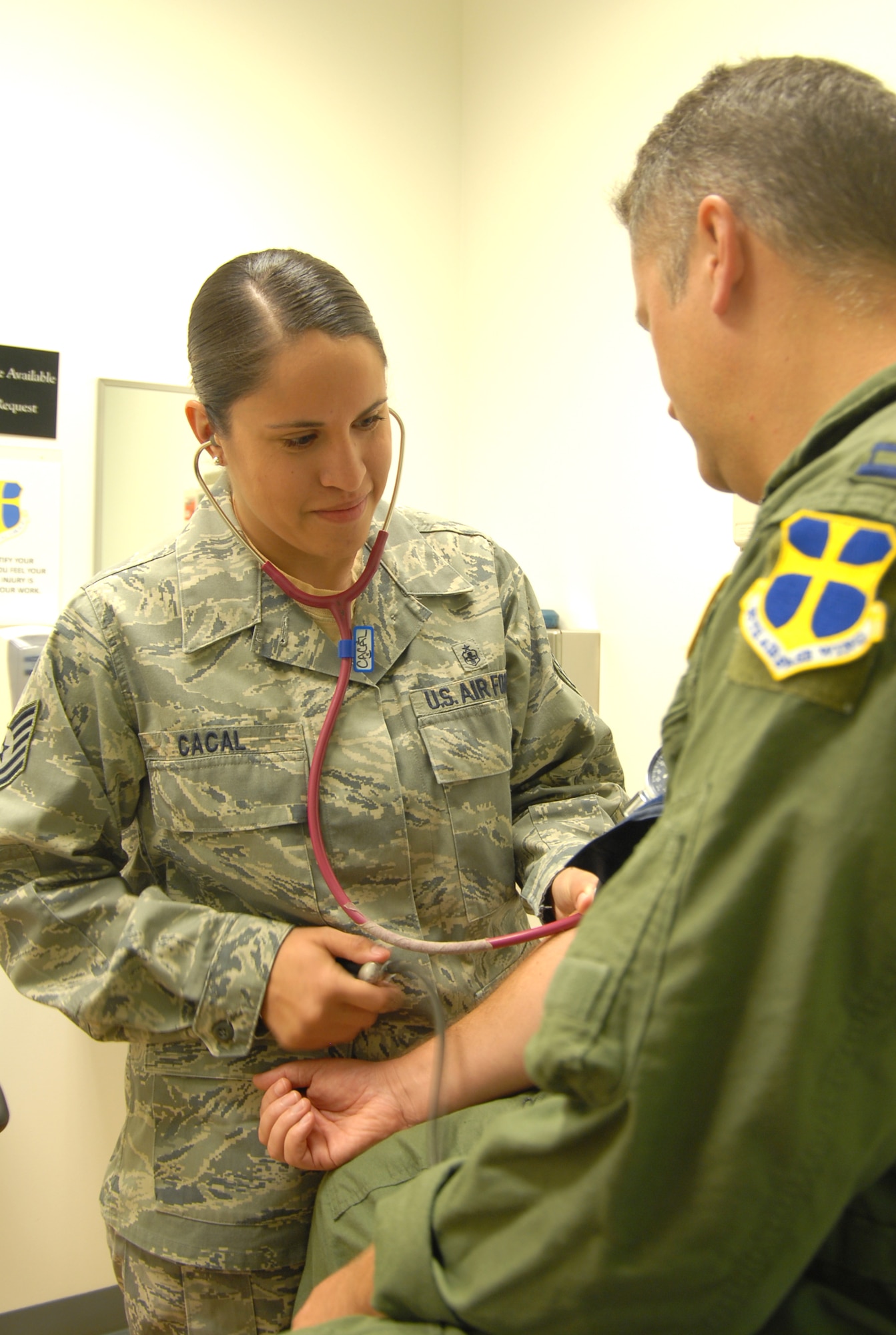 Tech. Sgt. Julianne Cacal, 95th Aerospace Medicine Squadron independent duty medical technician, checks a patient's blood pressure. As an IDMT, Sergeant Cacal diagnoses and treats servicemembers under the license of a supervising doctor. (U.S. Air Force photo/Senior Airman Julius Delos Reyes)