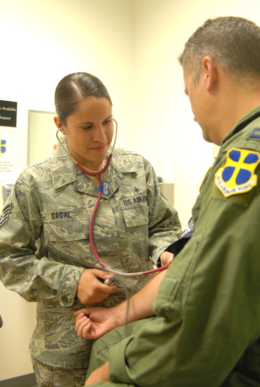 Tech. Sgt. Julianne Cacal, 95th Aerospace Medicine Squadron independent duty medical technician, checks a patient's blood pressure. As an IDMT, Sergeant Cacal diagnoses and treats servicemembers under the license of a supervising doctor. (U.S. Air Force photo/Senior Airman Julius Delos Reyes)