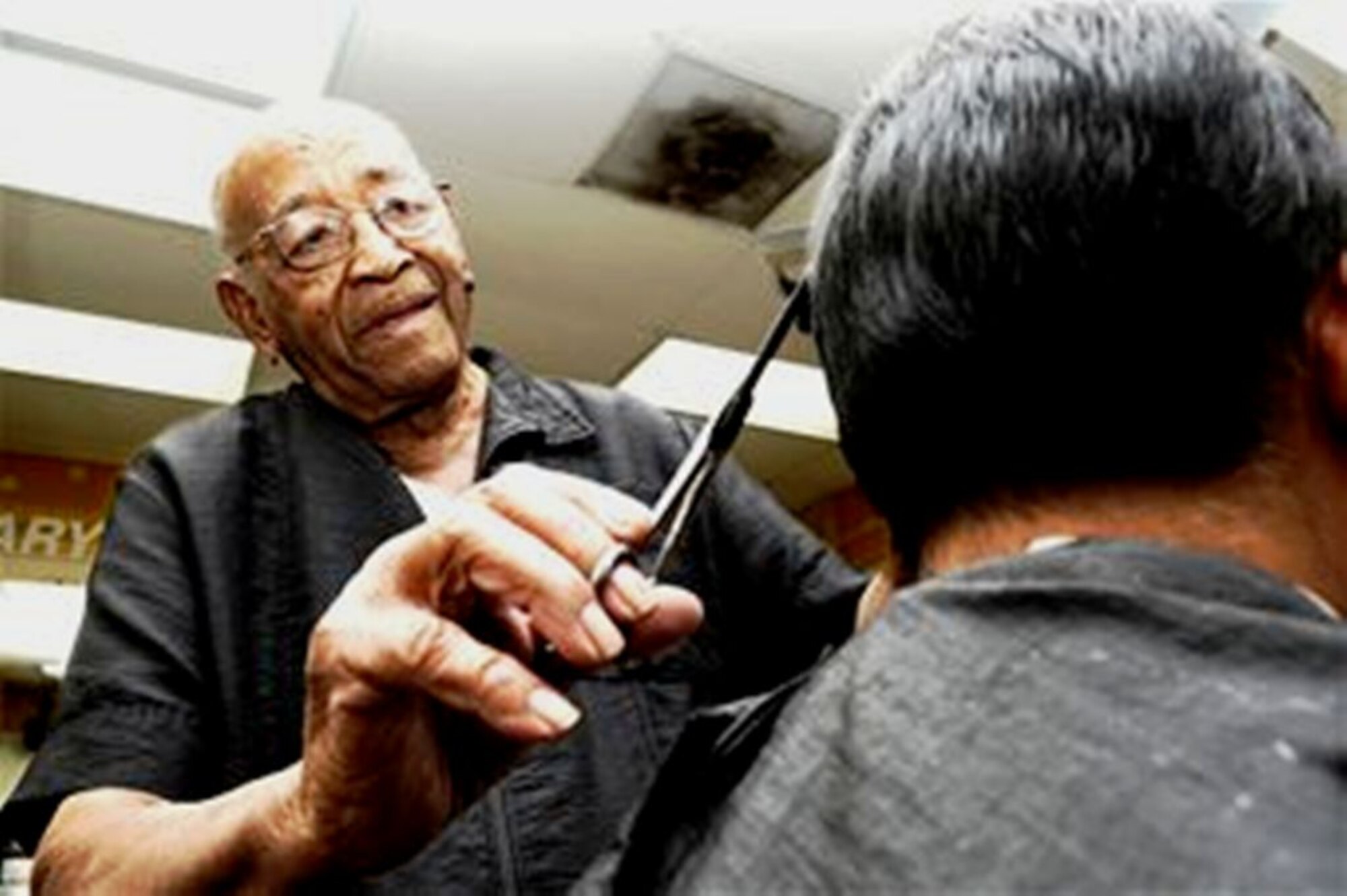 Mr. Mario Pujol, an 87-year-old barber and World War II veteran at MacDill Air Force Base, Fla., puts the finishing touches on a hairccut at the base barbershop July 21, 2009. Mr. Pujol came close to retiring in 2002, but said he is still around thanks to his boss, who talked him into sticking with it. (U.S. Air Force Photo/Senior Airman Nancy Hooks)