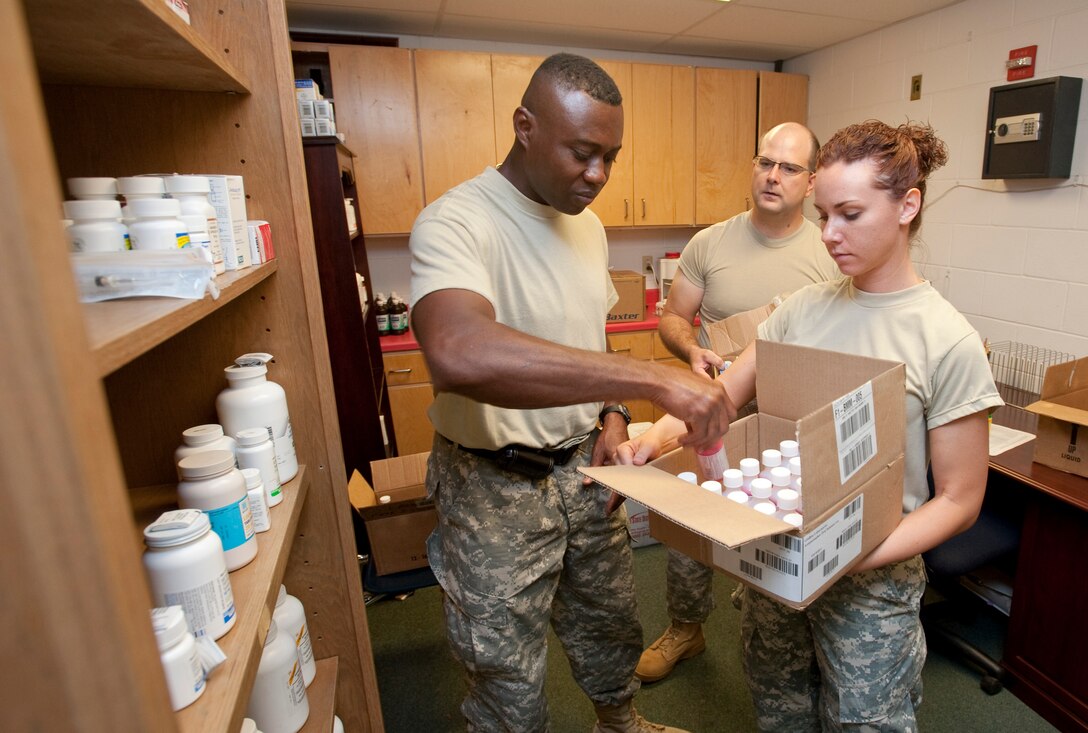 Maj. Alton Stewart from San Antonio Medcom, Capt. Eric Eliason from Camp Mabry Austin, and Sgt Keleigh Estes from Houston Medcom stock the pharmacy at the Raymondville, TX clinic for Operation Lone Star, July 26, 2009. (U.S. Air Force by Tech Sgt Charles Hatton)