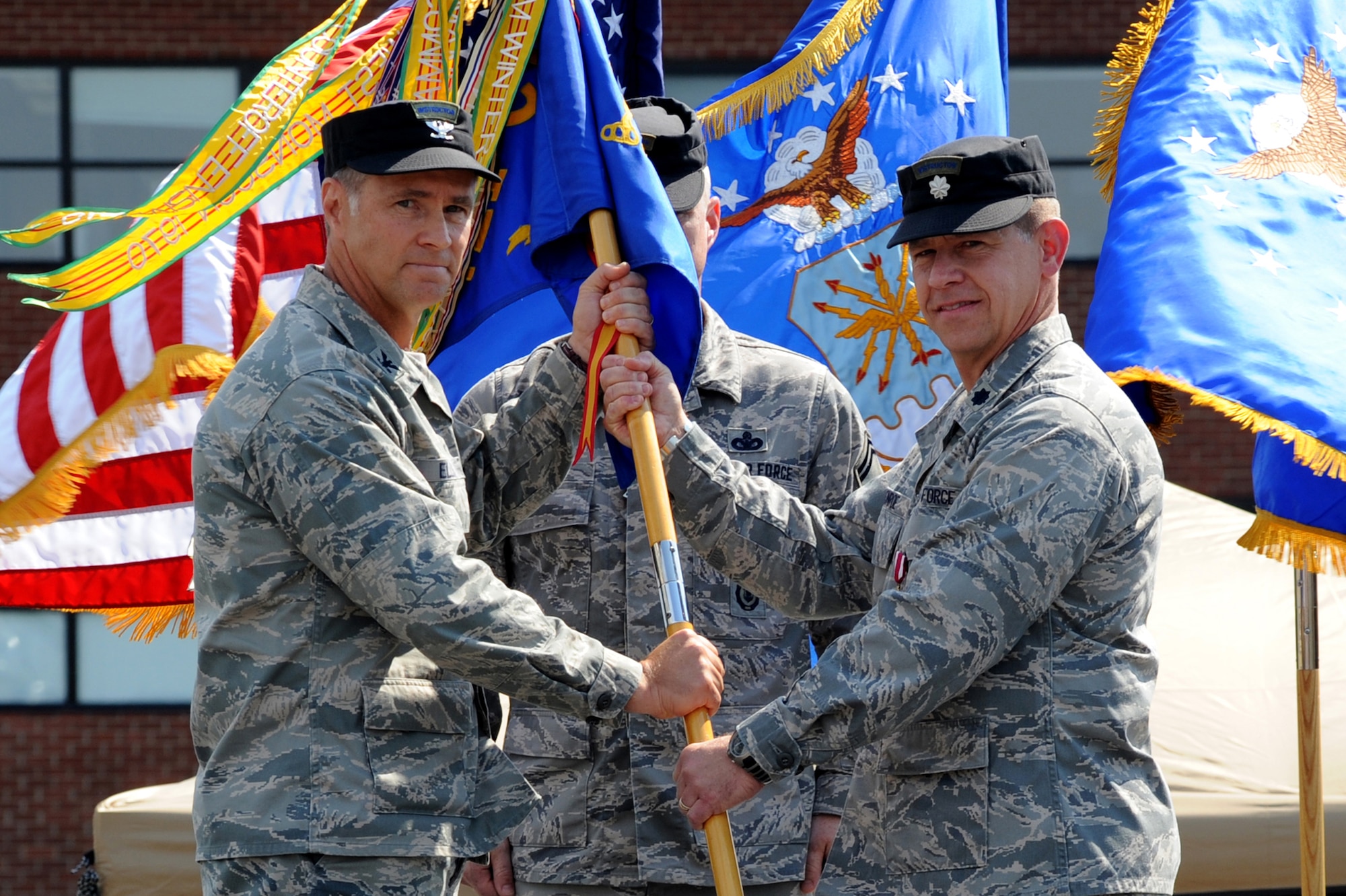 Col. Mark Ellis, Expeditionary Operations School commandant, accepts the 421st Combat Training Squadron guidon July 13 as Lt. Col. Mitchell Monroe relinquishes command during a change of command ceremony at Joint Base McGuire-Dix-Lakehurst, N.J.  Lt. Col. David Lenderman will assume command of the 421st CTS housed at the U.S. Air Force Expeditionary Center on Fort Dix. (U.S. Air Force Photo/Staff Sgt. Nathan G. Bevier) 