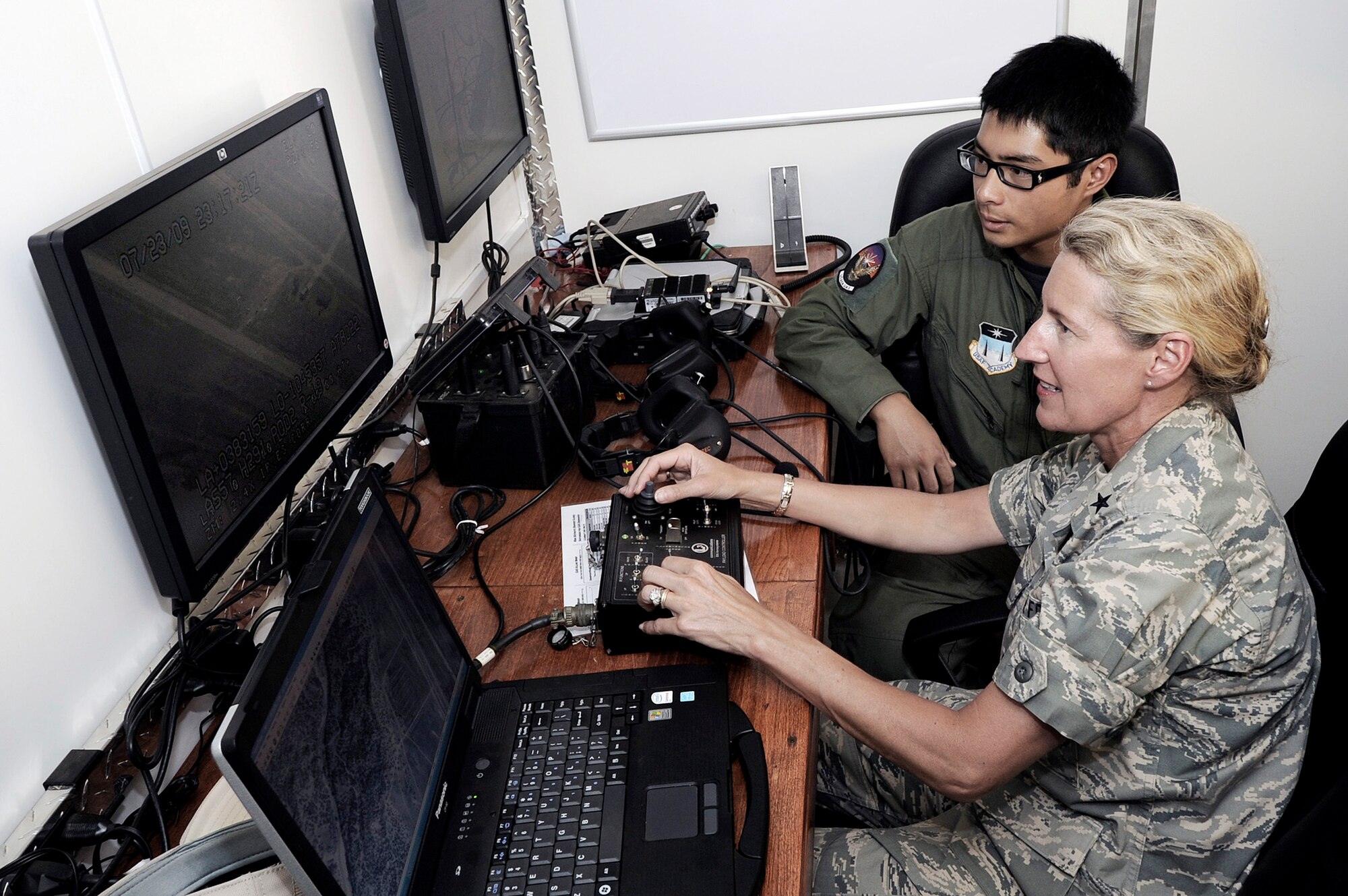 Brig. Gen. Dana H. Born operates a camera on a Viking 300 unmanned aircraft system as Cadet 2nd Class Rupert Domingo watches July 23 at Camp Red Devil at Fort Carson, Colo. Cadet Domingo is assigned to the U.S Air Force Academy's UAS program. General Born is the Academy dean of faculty. (U.S. Air Force photo/Mike Kaplan)