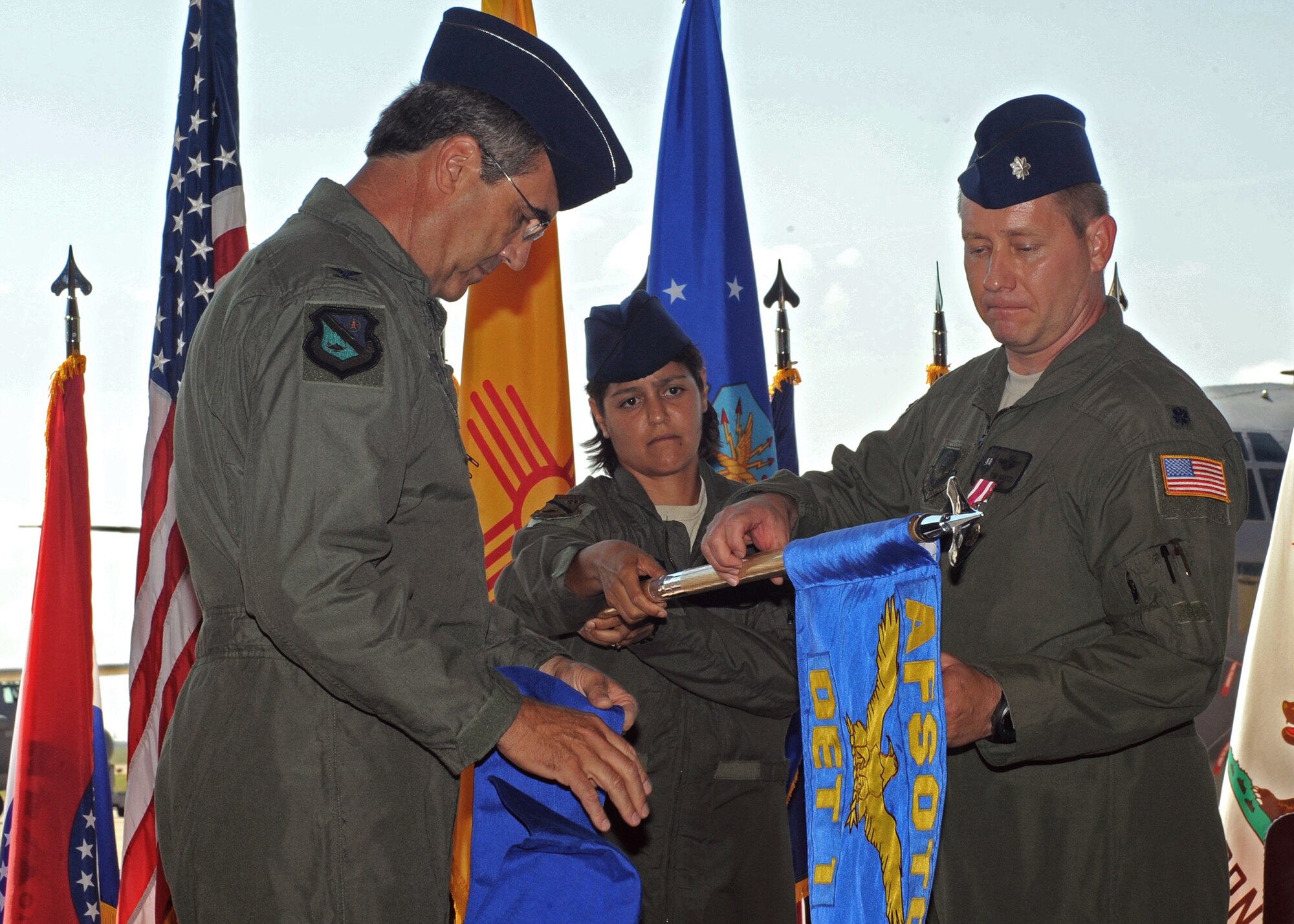 CANNON AIR FORCE BASE, N.M. -- Master Sgt. Susanne Parker (center), Air Force Special Operations Training Center Det. 1, holds the guidon as Colonel Paul Harmon (left), Air Force Special Operations Training Center commander, and Lt. Col.  Timothy Sartz (right), Air Force Special Operations Training Center Det. 1 commander, case the colors, inactivating the detachment July 24. The 551st Special Operations Squadron was then activated and will continue to train aircrews on multiple weapons systems on aircraft such as the MC-130W Combat Spear and AC-130H Spectre gunship.  (U.S. Air Force Photo by Staff Sgt. Heather R. Redman)