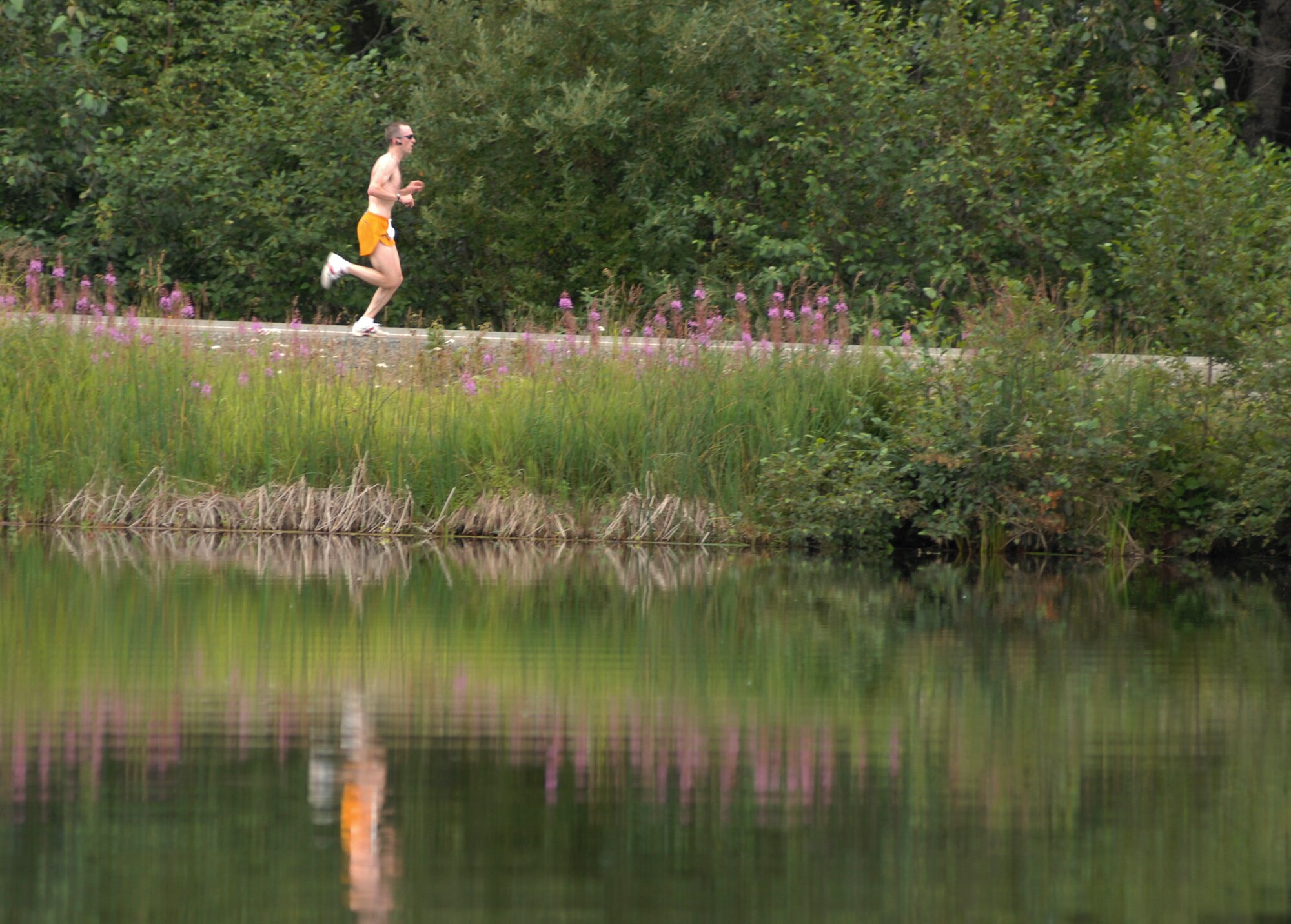 ELMENDORF AIR FORCE BASE, Alaska -- Daniel Knappmiller runs past Sixmile Lake during the Arctic Warrior Half Marathon July 25. Knappmiller was the winner of the half marathon with a time of 1 hour, 16 minutes, 26 seconds. Knappmiller is a captain with the 3rd Operations Support Squadron. (U.S. Air Force photo/Senior Airman David Carbajal)