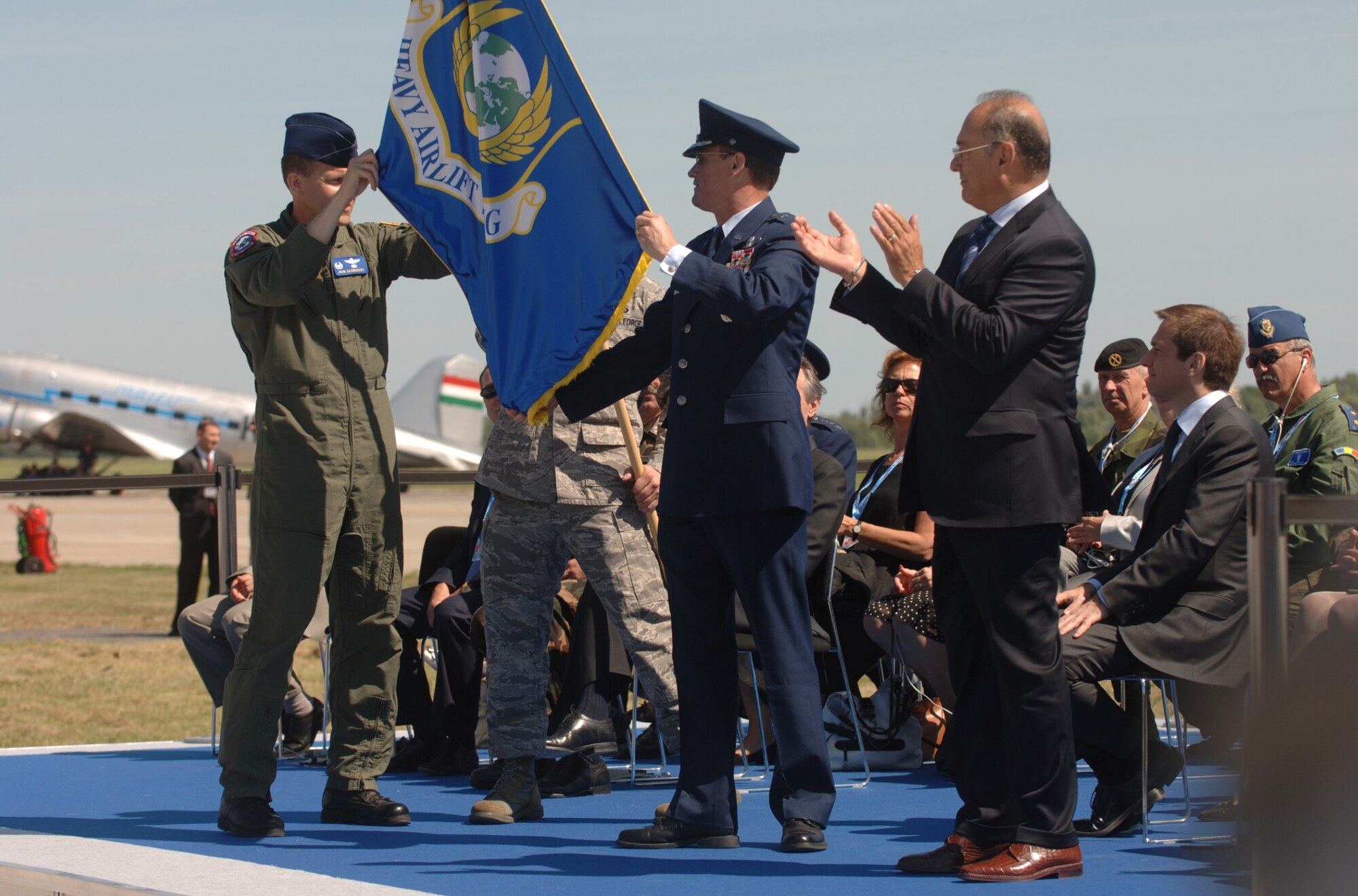 PAPA AIR BASE, Hungary--During the official activation ceremony of a first-of-its-kind multinational Heavy Airlift Wing at Papa Air Base, Hungary on Jul. 27, U.S. Air Force Col. John Zazworsky and Brig. Gen. Richard Johnston unveil the organizational flag.  The ceremony celebrated the efforts of the 12 nations who, over the last 10 months, stood up the organization that will provide strategic airlift worldwide for humanitarian, disaster relief, and peacekeeping missions in support of the European Union, United Nations and NATO. (Depart of Defense photo/Master Sgt. Scott Wagers