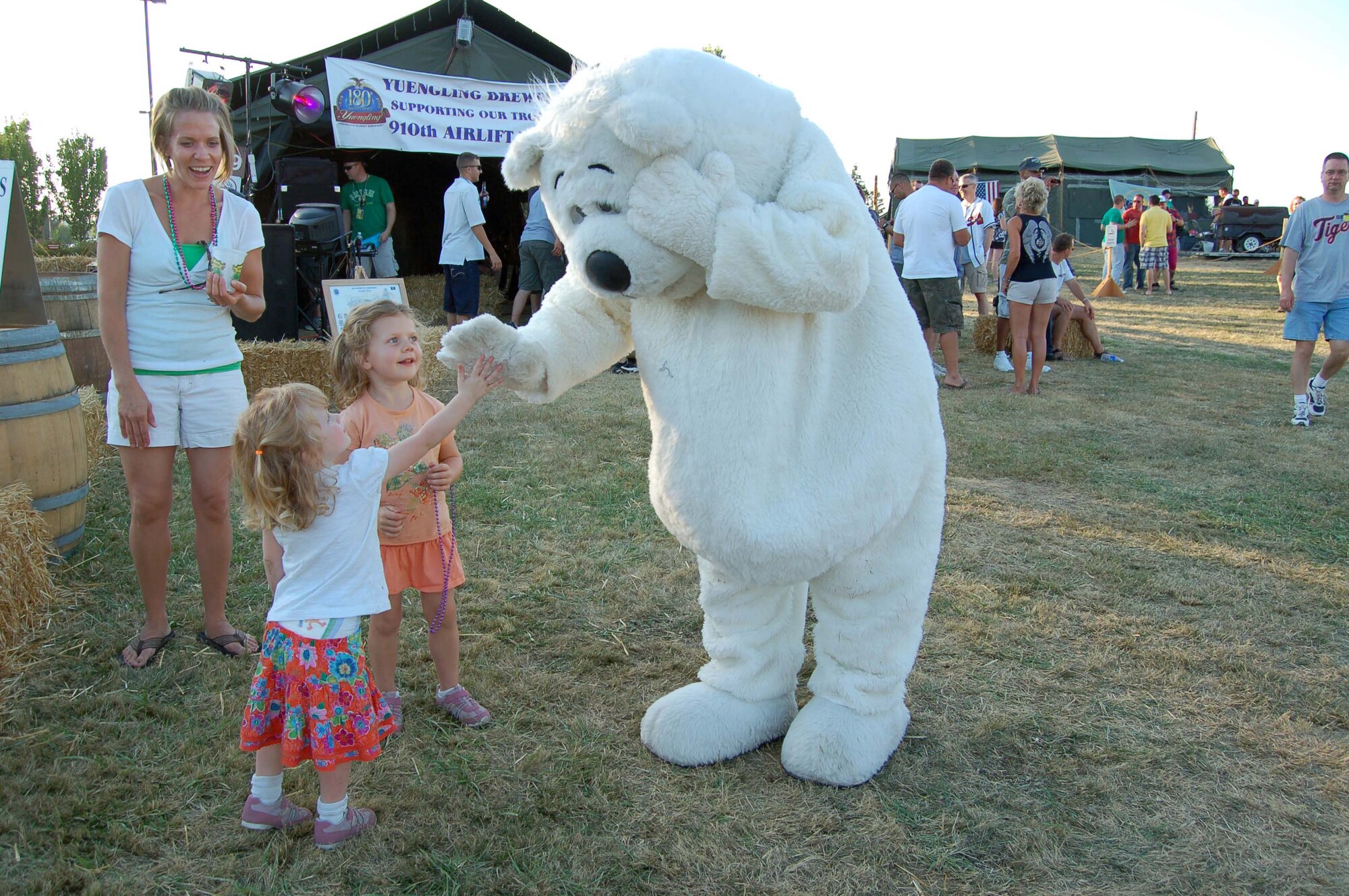 Dakota the Bear, played by Airman 1st Class Mike Beauman, 319th Comptroller Squadron, greets a child while exploring Renier Ranch during the 2009 Air Mobility Rodeo competition on McChord AFB, Wash. (U.S. Air Force photo/Tech. Sgt. Amanda Callahan)