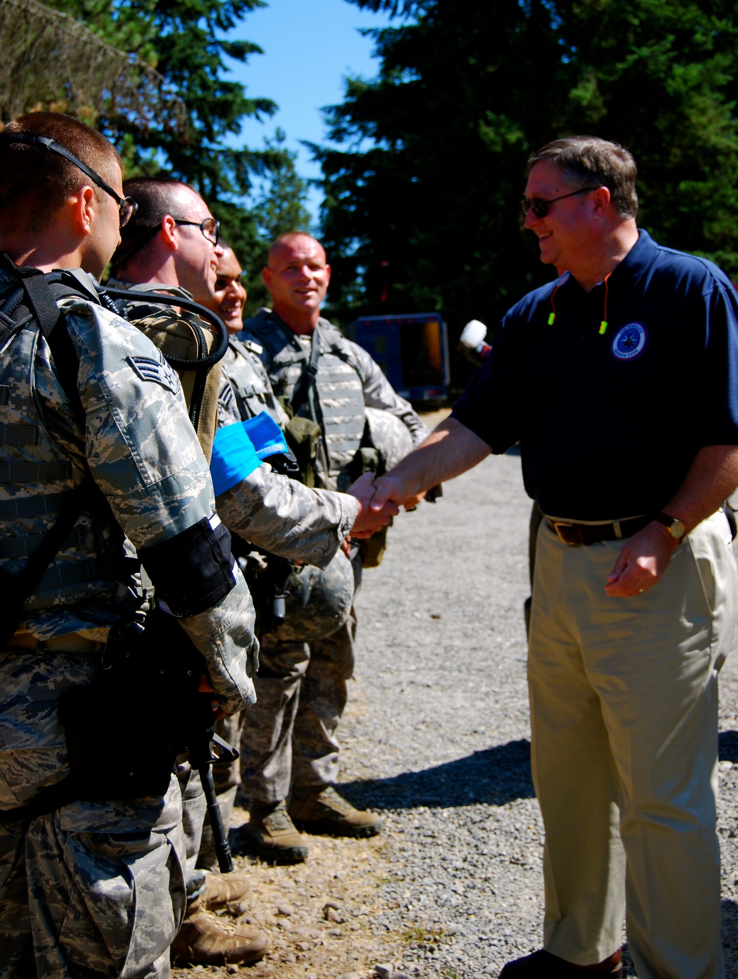 Secretary of the Air Force Michael B. Donley shakes hands with Senior Airman James New, 436th Security Forces Squadron, after observing their combat weapons exercise July 22 at the Air Moblity RODEO 2009, McChord Air Force Base, Wash. The security forces team competed against bases worldwide in graded events such as combat tactics, combat endurance and fit-to-fight. (U.S. Air Force photo/Staff Sgt. Steve Lewis)
