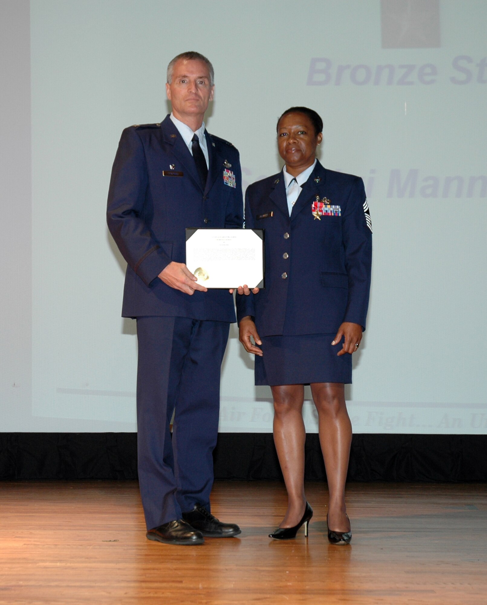 Colonel Steven Chapman, Commander of the 315th Airlift Wing, Charleston Air Force Base, S.C., presents Chief Master Sergeant Gigi B. Manning with the Bronze Star Medal. (Air Force photo / Maj Bill Walsh)