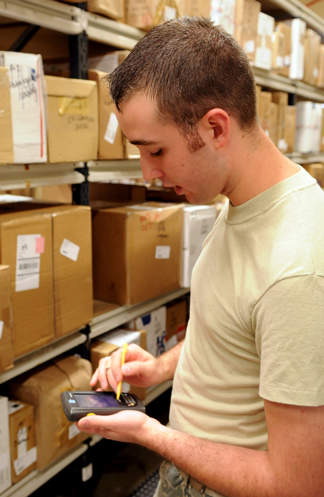 RAF MILDENHALL, England – Senior Airman Tyler Wasson, RAF Mildenhall post office, scans boxes into a computer system that tracks them for easy retrieval when the customer comes for them.   A printout placed in the member’s mailbox tells the postal clerk the exact location of the box, making the process quick for all involved.  (U.S. Air Force photo by Staff Sgt. Austin M. May)