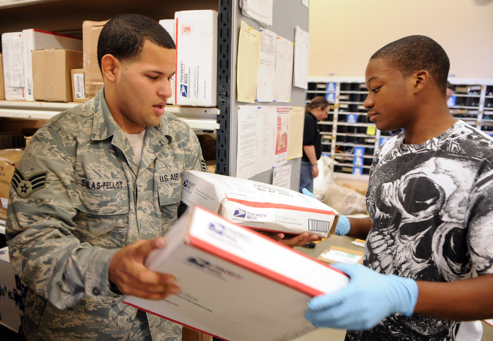 RAF MILDENHALL, England – Senior Airman Victor Salas-Pellot and Steve Saxon, RAF Mildenhall post office, sort the morning’s packages for delivery later that day.  Once the hundreds of boxes and envelopes arrive each day, each one is placed on a shelf and scanned into a computer system which makes it quicker and easier to find when the customer comes calling. (U.S. Air Force photo by Staff Sgt. Austin M. May)