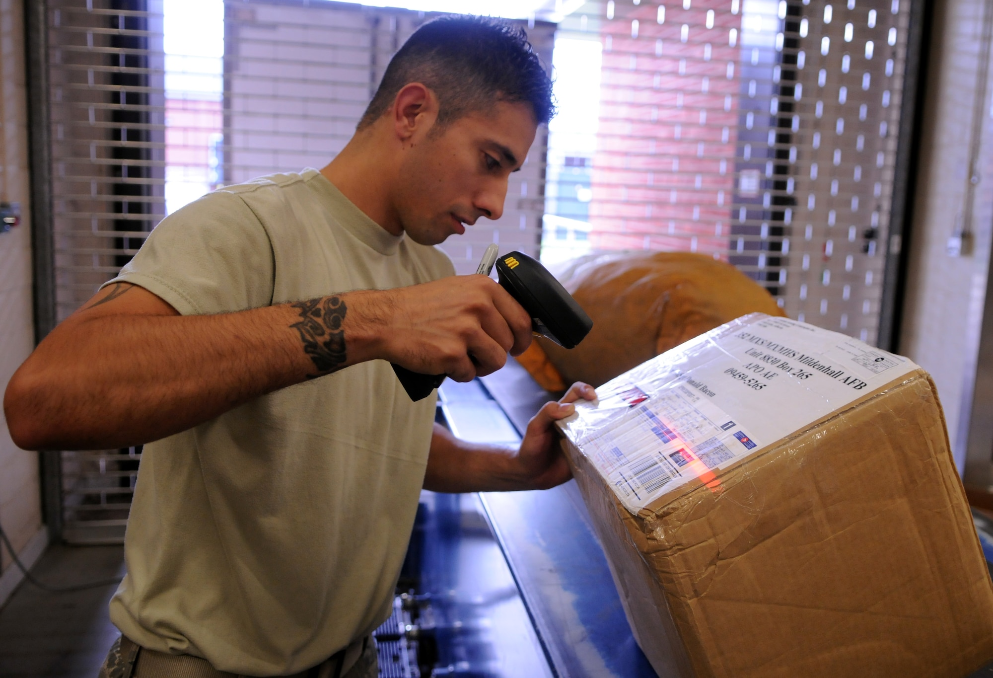 RAF MILDENHALL, England -- Staff Sgt. Jesse Dunn, RAF Mildenhall post office, scans a package as it arrives at the postal service center in the early morning.  Postal clerks handle thousands of boxes a week, ensuring the members of Team Mildenhall get their mail in a timely fashion.  (U.S. Air Force photo by Staff Sgt. Austin M. May)