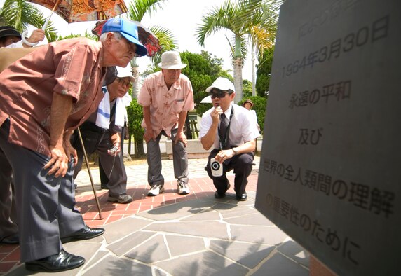 Hideaki Sakihama, 18th Wing Public Affairs community relations specialist, reads to 90 visitors from a monument referring to Japan's surrender at Kadena Air Base, Japan, July 23. The locals are from the Okinawa Prefectural Disabled Veterans Association visiting war-related sites such as the Peace Garden and an old aircraft hanger. The group is unique as they served in the Imperial Japanese Army during the Battle of Okinawa, sustained injuries in the war, and have been receiving military pensions from the Government of Japan. They were not directly deployed to Okinawa during the war, but drafted from here to serve in the Army. (U.S. Air Force photo/Tech. Sgt. Rey Ramon) 