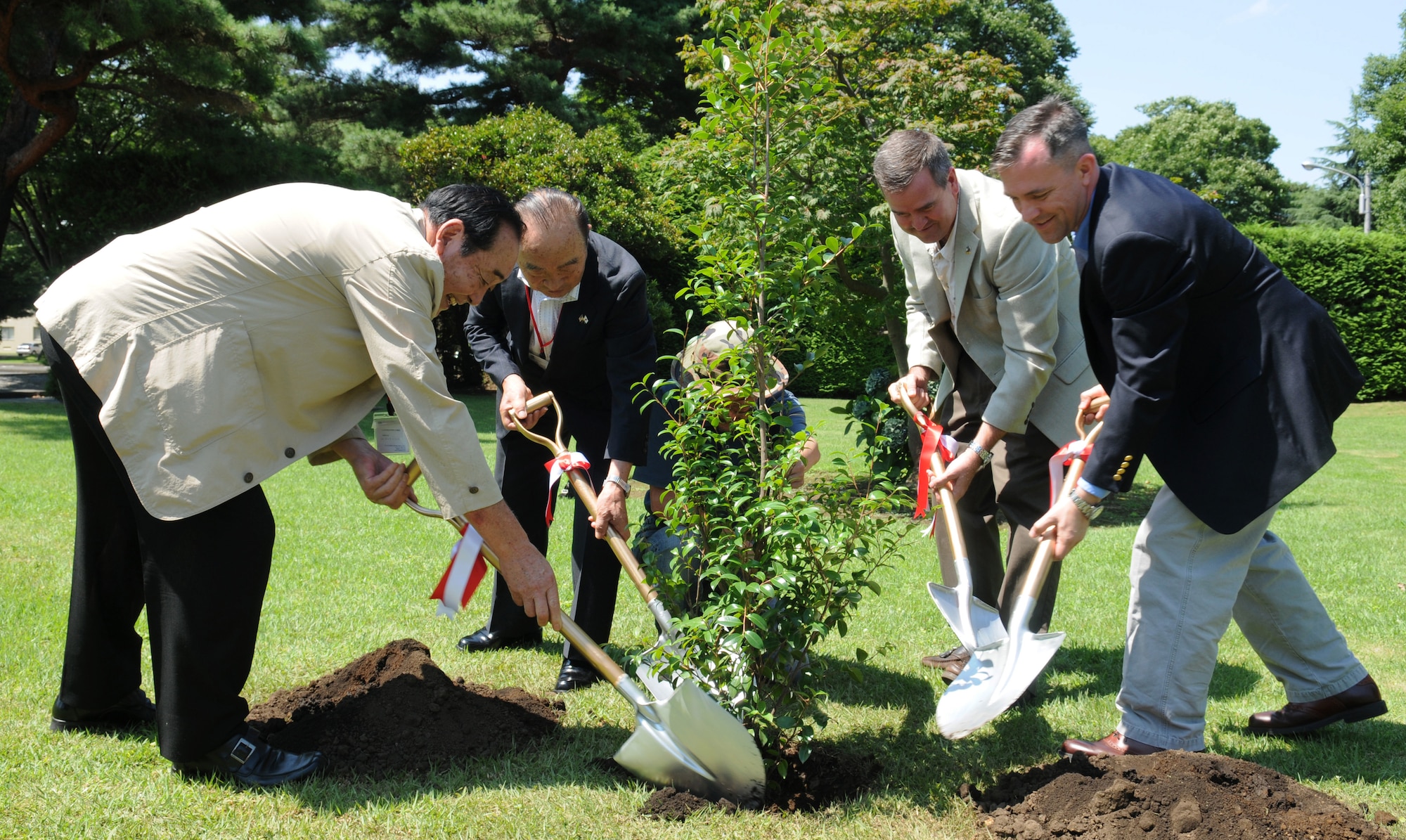 YOKOTA AIR BASE, Japan -- Members of the 374th Operations Group and the Musashimurayama Yokota Friendship Club plant a Sazanka tree, native to southern Japan, July 26 near the Yujo Community Center. The tree stands as a symbol of the friendship between the citizens of Musashimurayama and members of the 374th Operations Group. The event coincided with the second anniversary of the friendship club. (U.S. Air Force photo/Airman 1st Class Sean Martin)