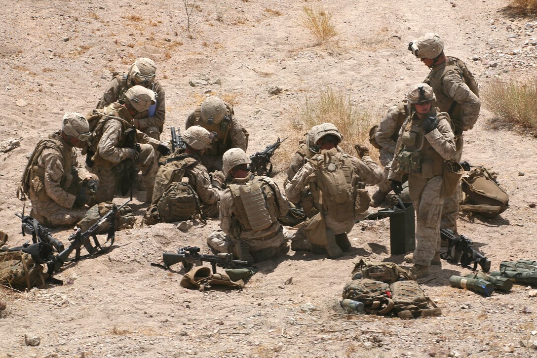 U.S. Marines reload magazines for fellow Marines at firing positions ...